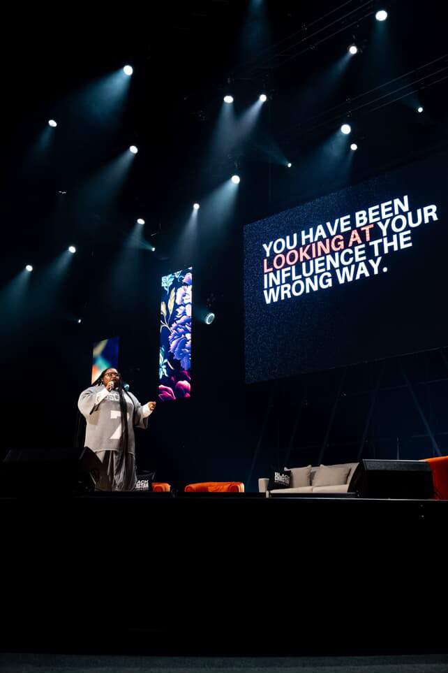 Kendra Taul speaking on stage in front of a screen