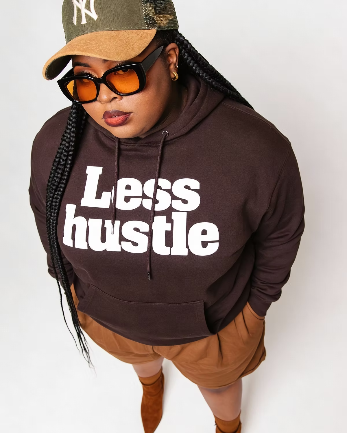 Portrait wearing sunglasses and a Less hustle hoodie