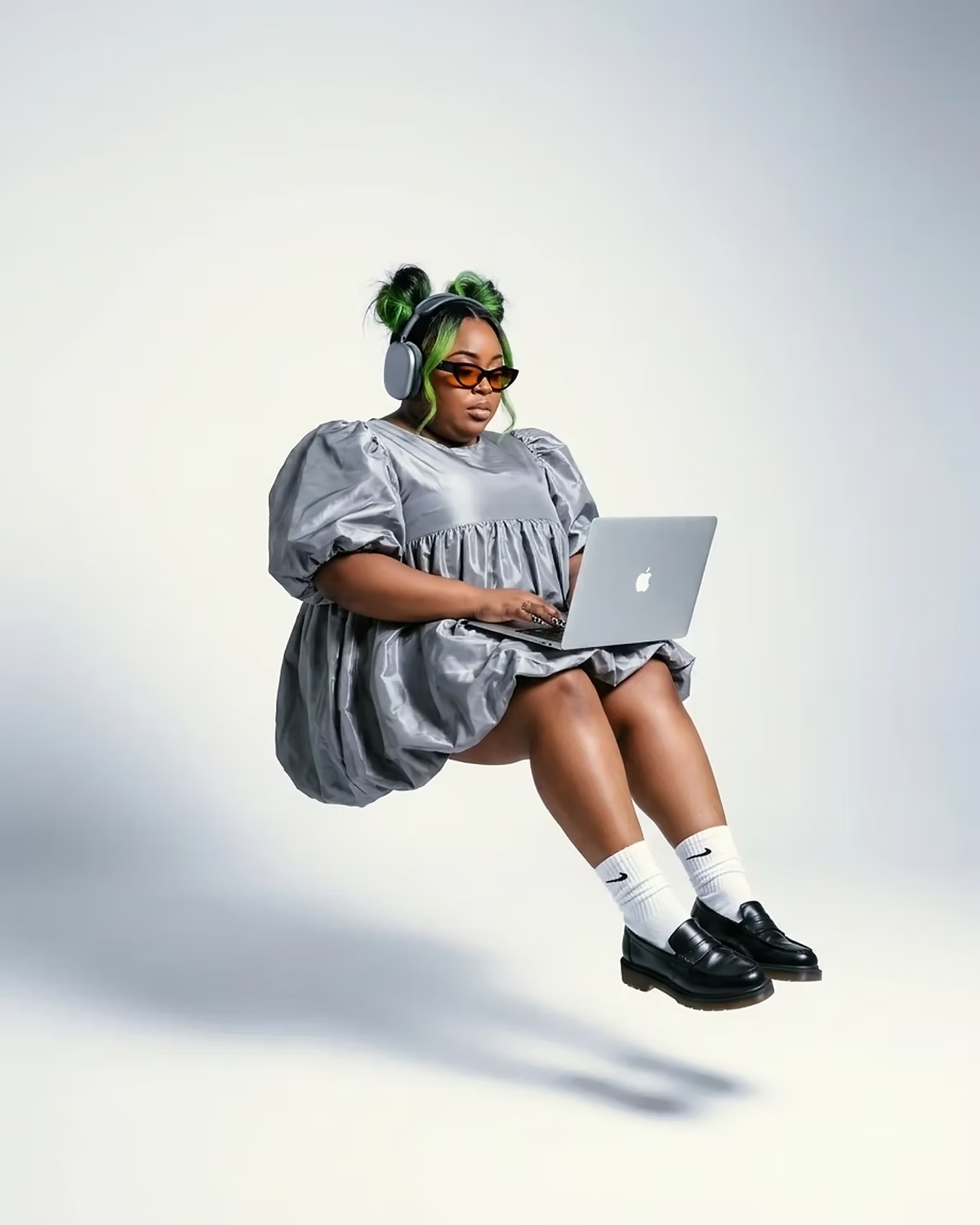 Floating portrait working on a laptop in a silver dress